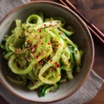 Korean cucumber salad served in a rustic bowl with chili flakes
