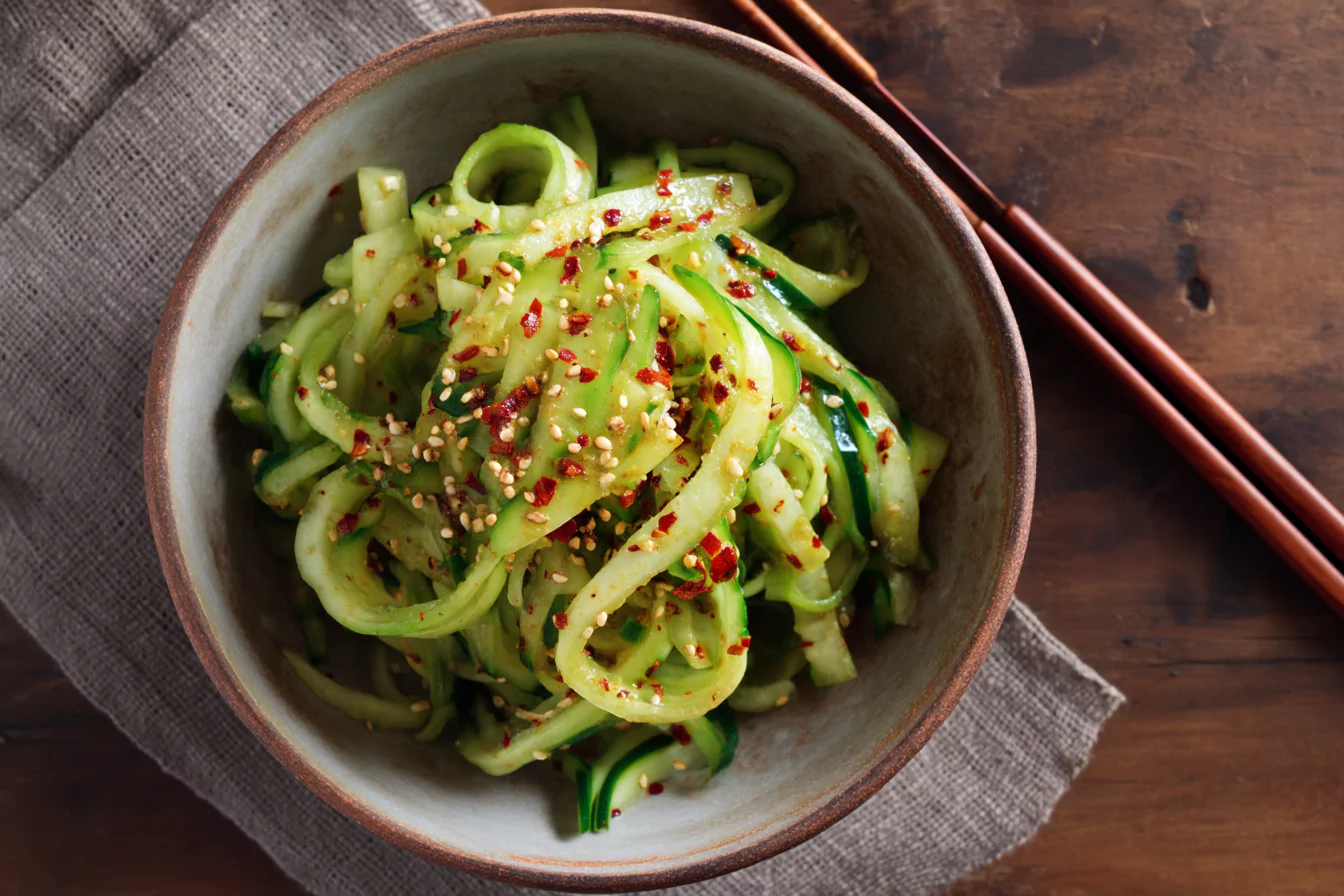 Korean cucumber salad served in a rustic bowl with chili flakes