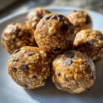 No-bake peanut butter energy bites on a plate with oats and chocolate chips