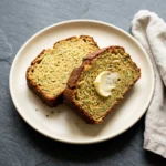 Slice of easy gluten-free zucchini bread on a wooden cutting board