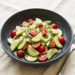 A vibrant cucumber basil salad served in a bowl, featuring fresh ingredients.