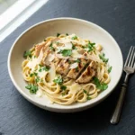 High protein garlic parmesan pasta bowl topped with fresh herbs and parmesan cheese.