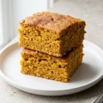 Bowl of pumpkin baked oatmeal topped with nuts and spices