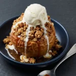 Baked apples with oat topping served on a plate, garnished with cinnamon