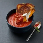 Delicious bowl of homemade roasted tomato soup with fresh basil garnish